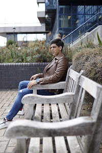 Young Man Resting on Weathered Park Bench