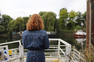 Woman Smiling Outdoors Near Stone Bridge