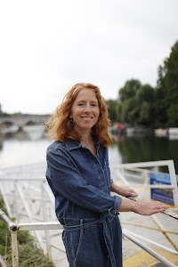 Woman Smiling Outdoors Near Stone Bridge