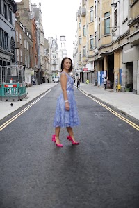 Woman in Blue Lace Dress on London Cobblestone Street