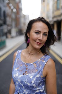 Woman in Blue Lace Dress on London Cobblestone Street