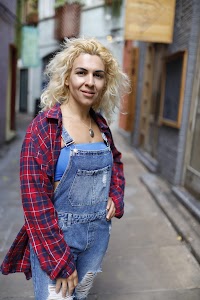 Woman Seated on Bench Outside Urban Shopfront