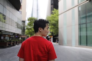 Young Man in Red T-Shirt on Urban Street