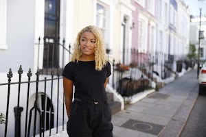 Young Woman Posing on Pastel Terraced Street