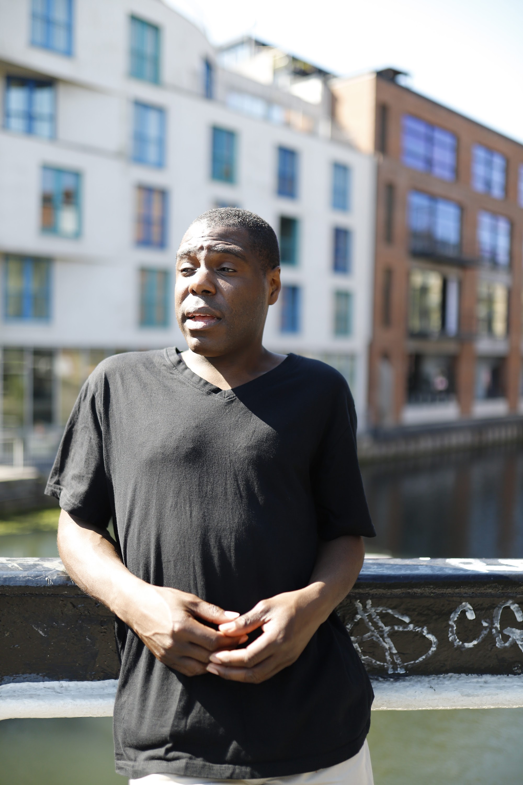 Man Leaning on Canal Bridge Railing