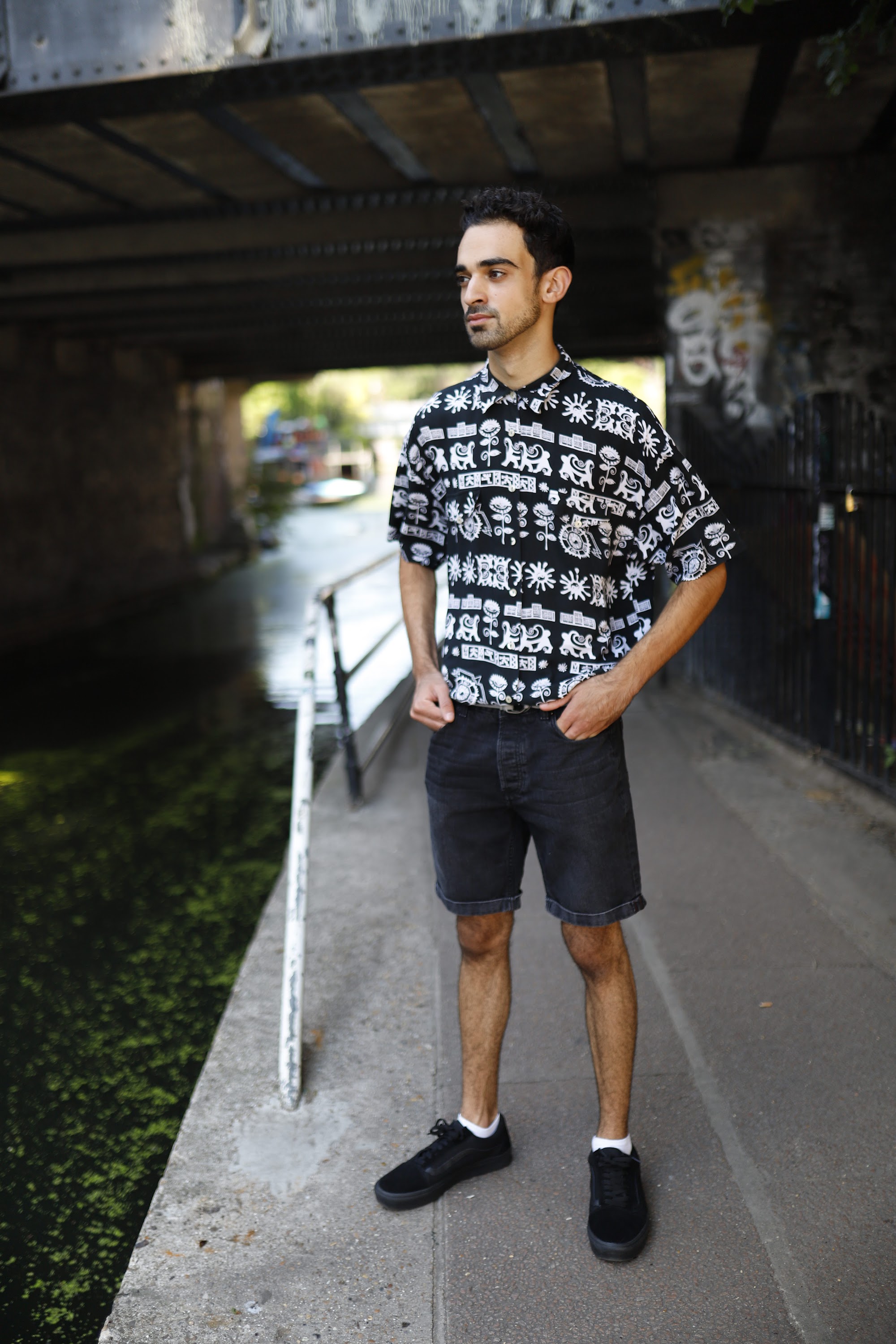 Young Man in Patterned Shirt Against Graffiti Wall