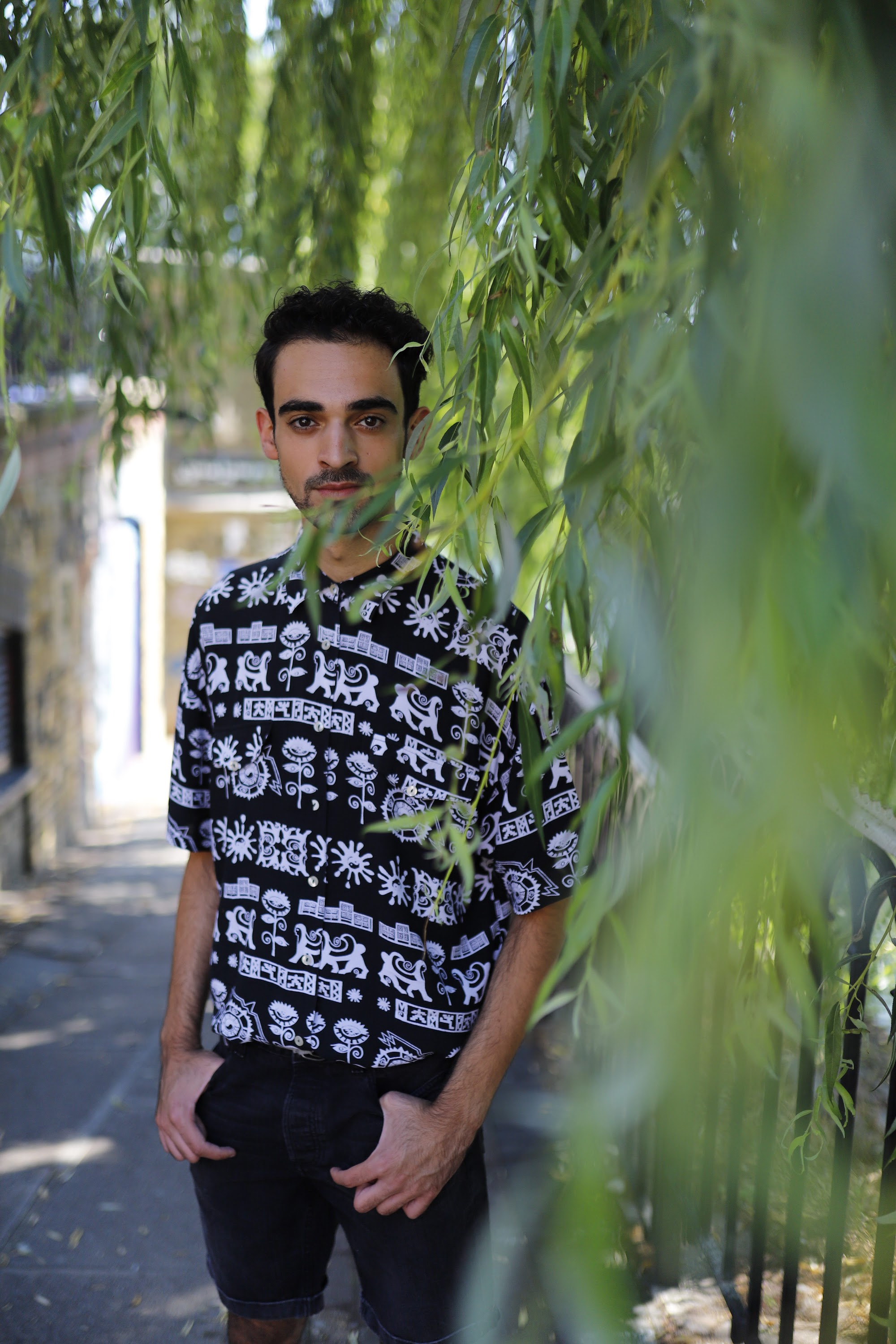 Young Man in Patterned Shirt Against Graffiti Wall