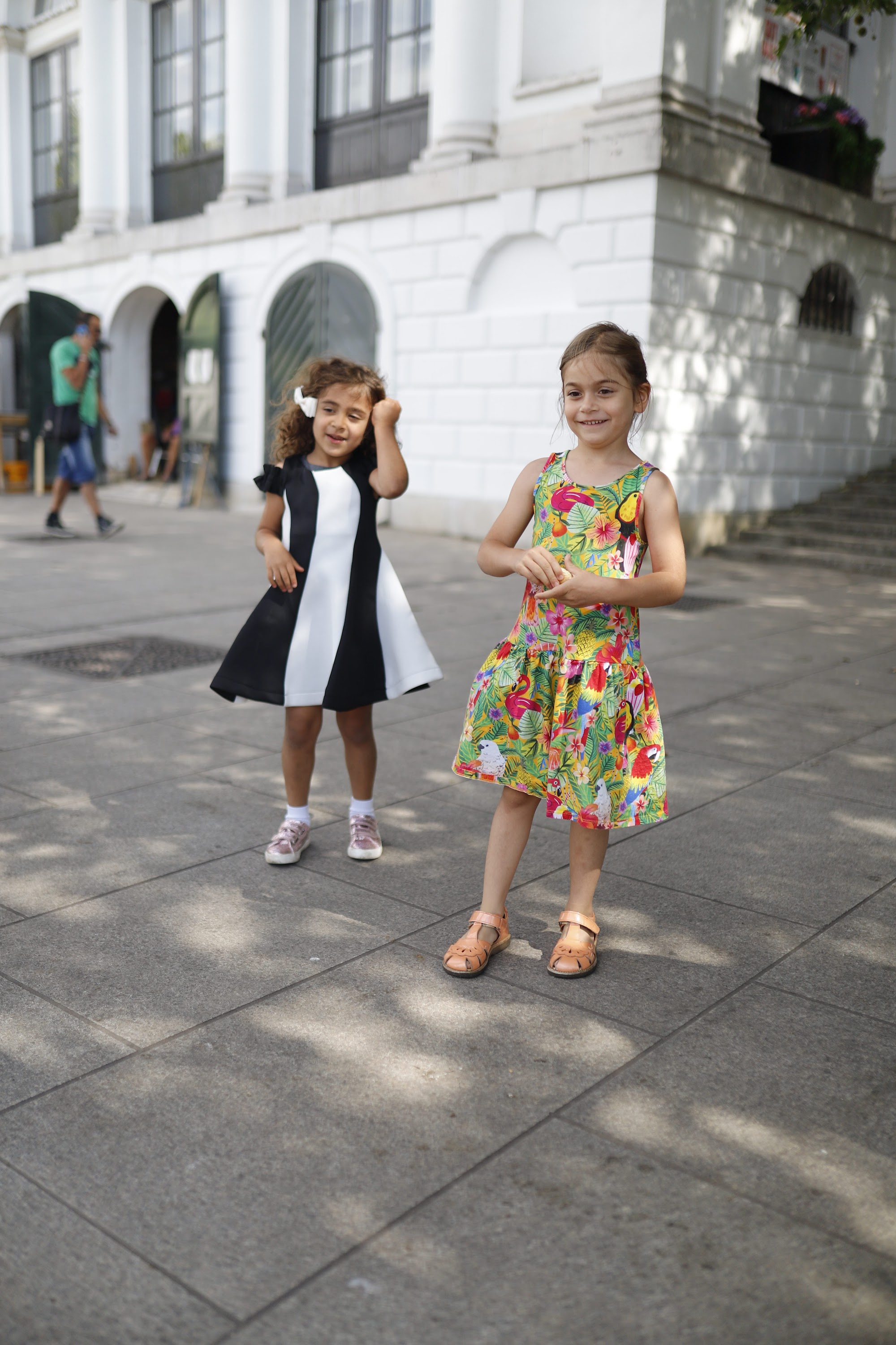 Two Young Girls Seated on Urban Concrete Ledge