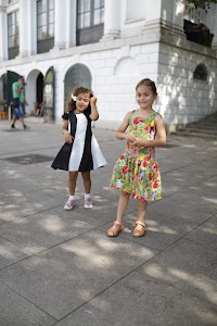 Two Young Girls Seated on Urban Concrete Ledge