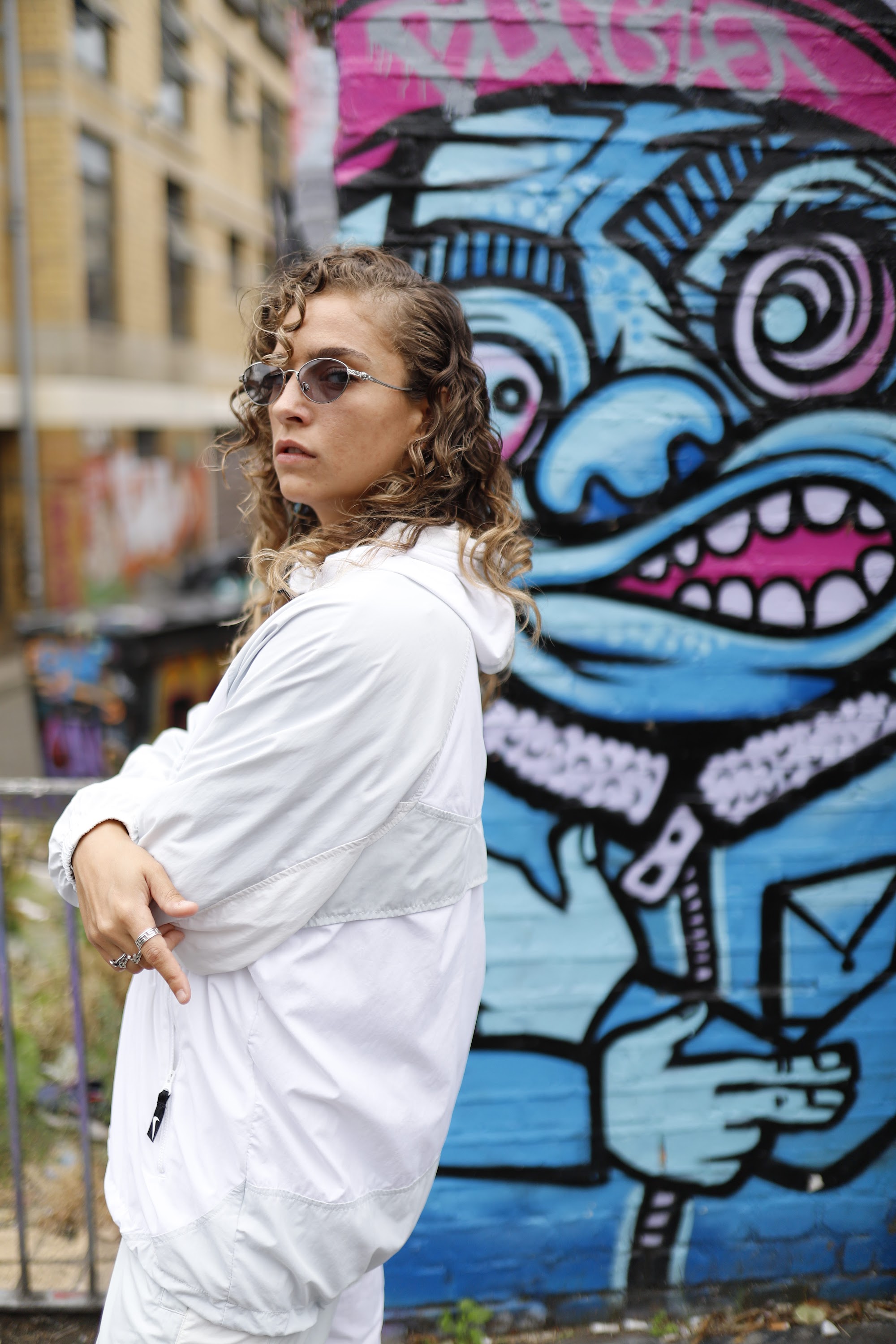 Woman in White Jacket Holding Sunglasses – Dark Urban Tunnel