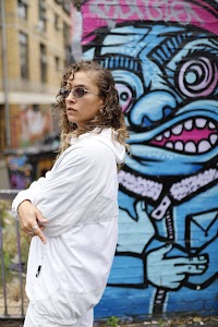 Woman in White Jacket Holding Sunglasses – Dark Urban Tunnel