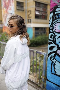 Woman in White Jacket Holding Sunglasses – Dark Urban Tunnel