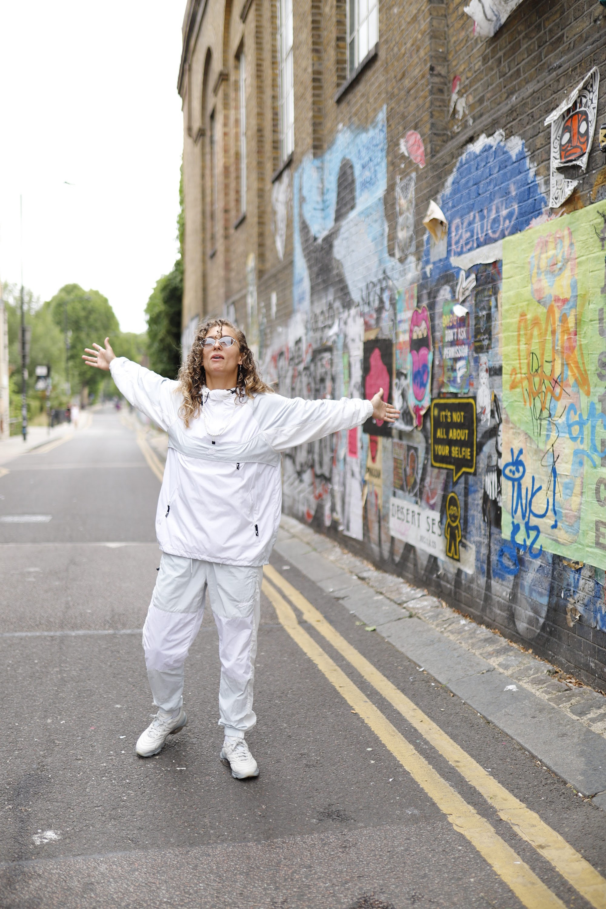 Woman in White Jacket Holding Sunglasses – Dark Urban Tunnel