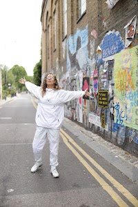 Woman in White Jacket Holding Sunglasses – Dark Urban Tunnel