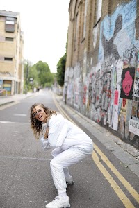 Woman in White Jacket Holding Sunglasses – Dark Urban Tunnel