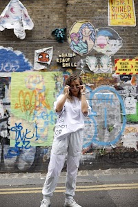 Woman in White Jacket Holding Sunglasses – Dark Urban Tunnel
