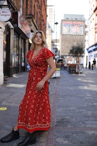 Young Woman in Floral Dress at Indoor Arcade Corridor
