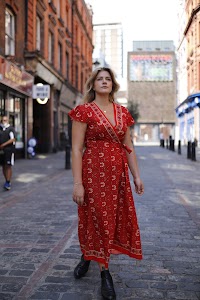 Young Woman in Floral Dress at Indoor Arcade Corridor