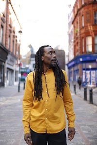 Man in Yellow Shirt on Cobblestone City Street
