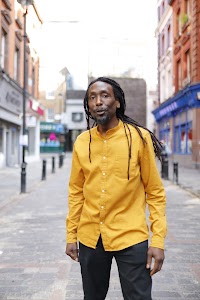 Man in Yellow Shirt on Cobblestone City Street