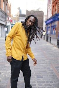 Man in Yellow Shirt on Cobblestone City Street