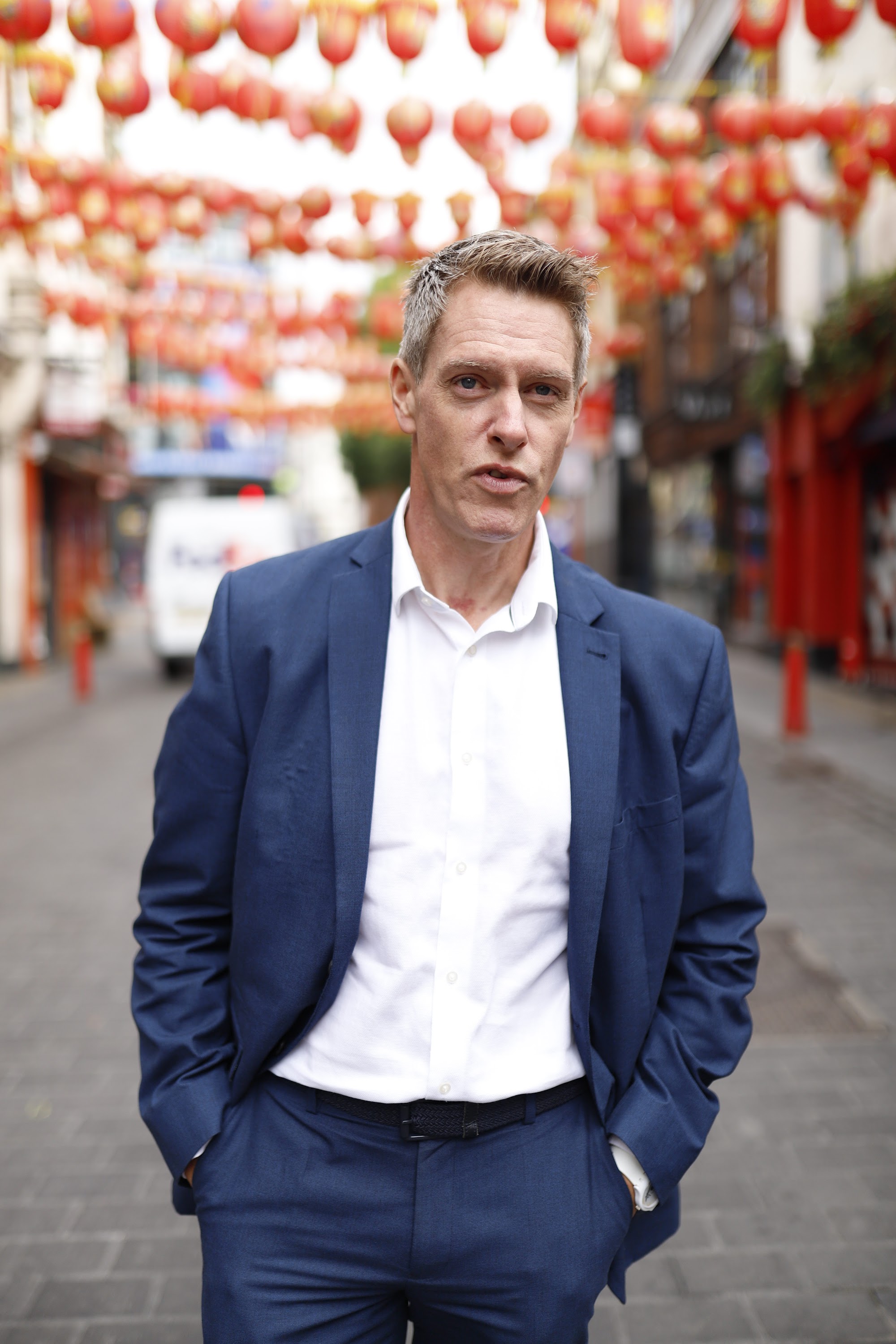 Man in Navy Suit on Cobblestone Urban Street