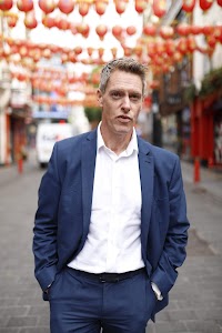 Man in Navy Suit on Cobblestone Urban Street
