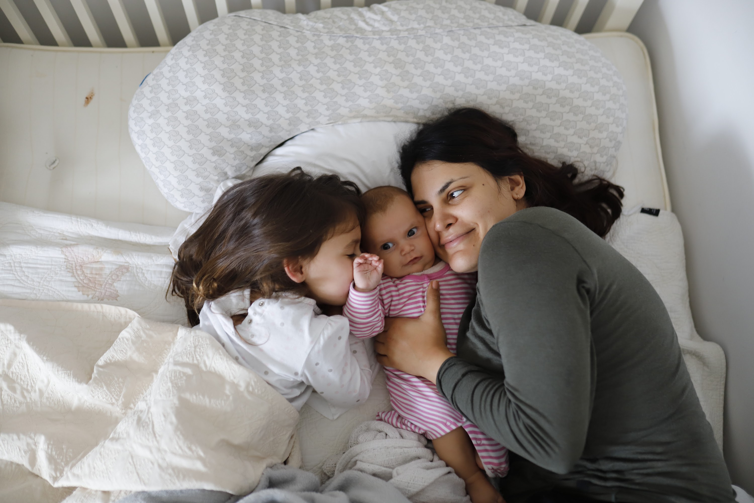 Mother and Daughters Resting Together in Bed