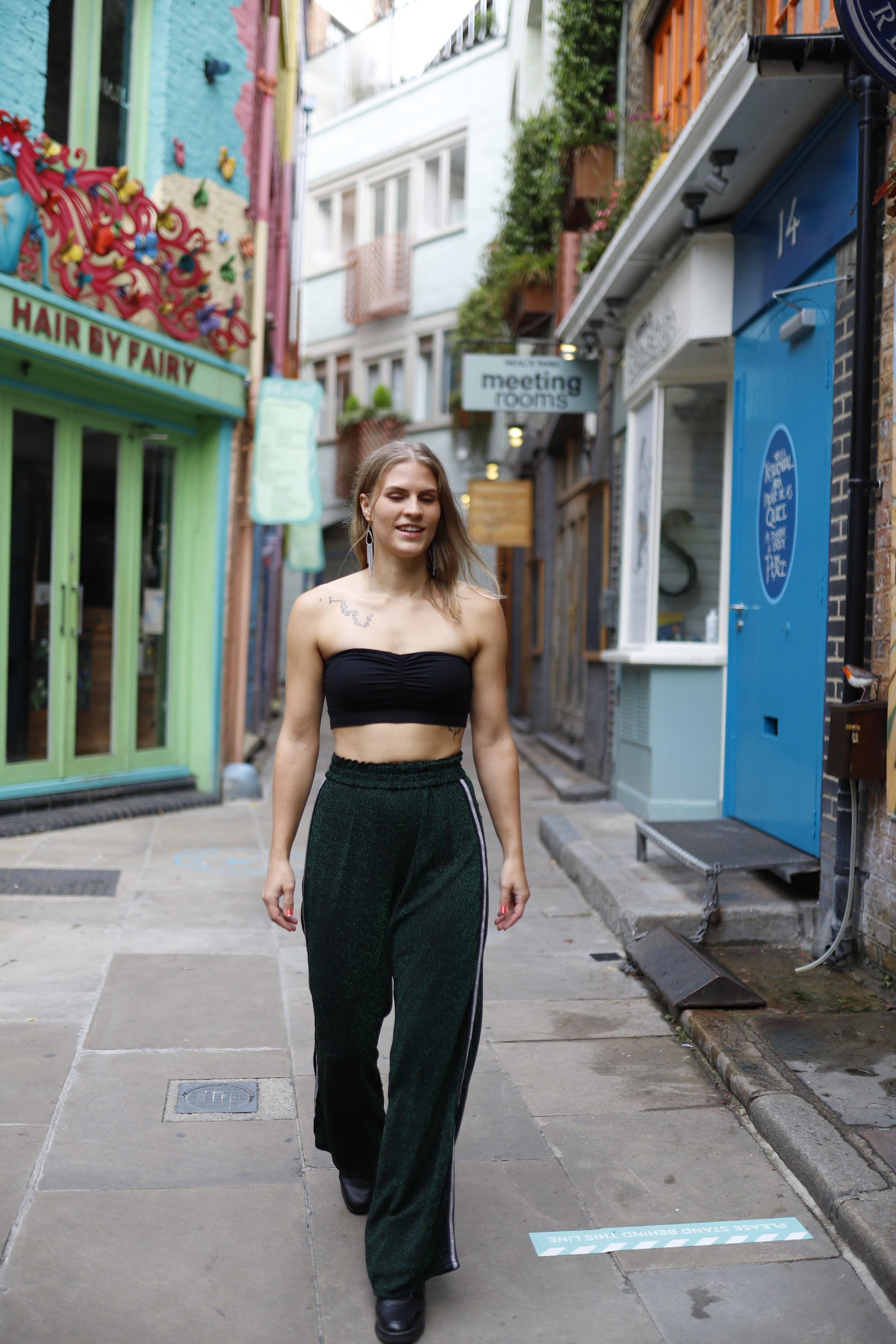 Young Woman Seated Outdoors in Colorful Urban Alley