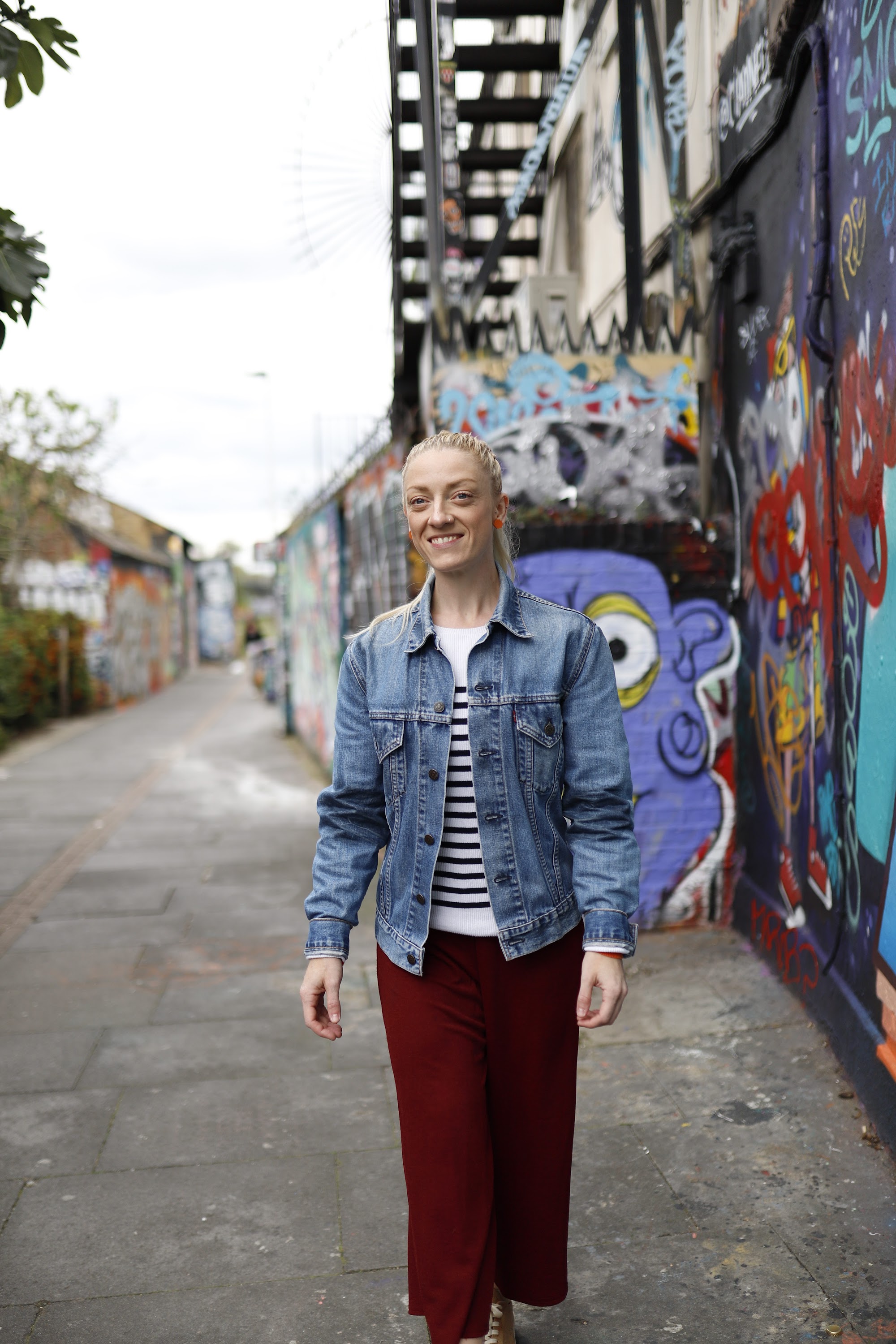 Blonde Woman in Burgundy Jumpsuit on Urban Street