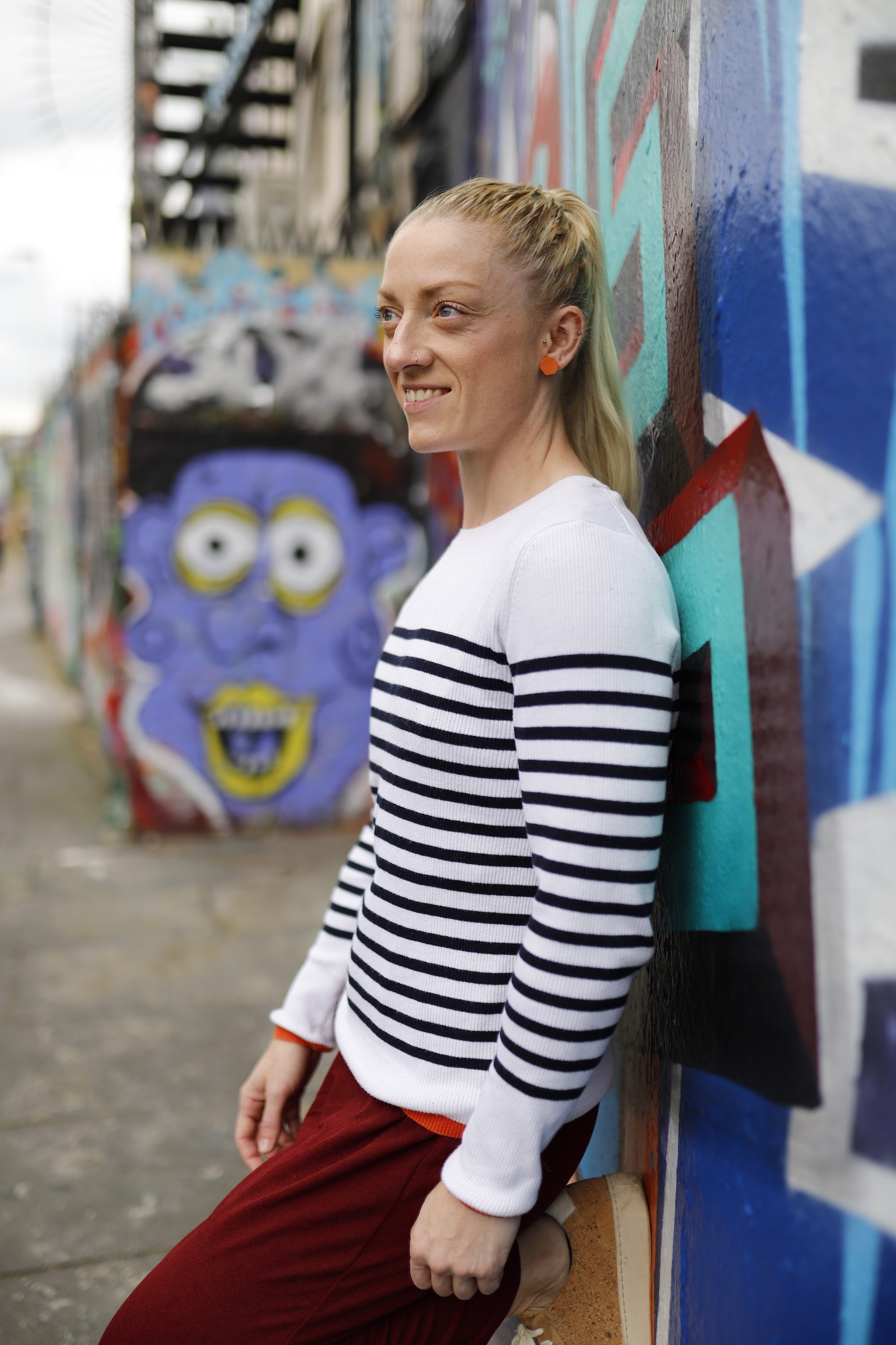 Blonde Woman in Burgundy Jumpsuit on Urban Street