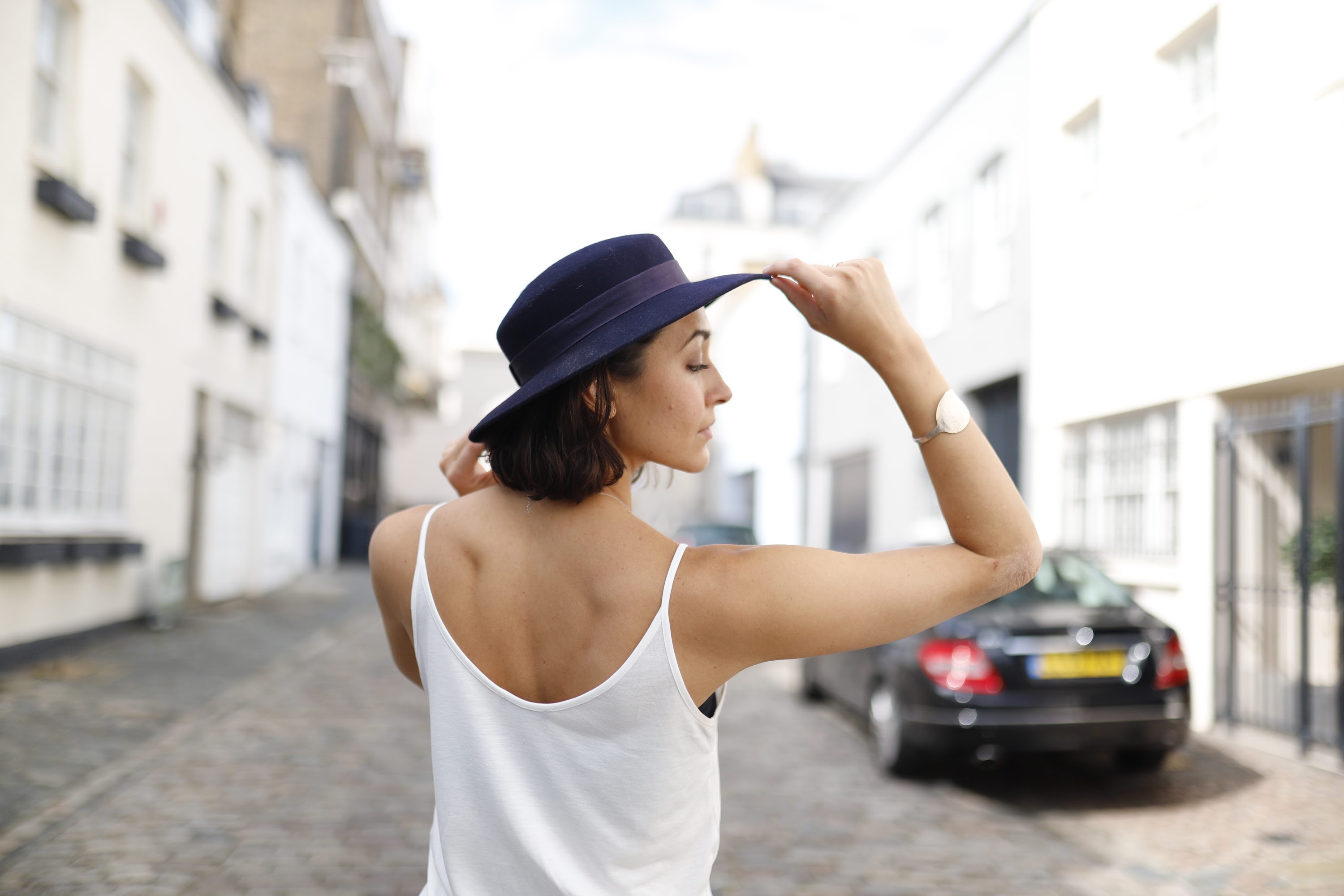 Young Woman Speaking Outdoors Against White Brick Wall