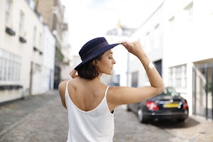 Young Woman Speaking Outdoors Against White Brick Wall