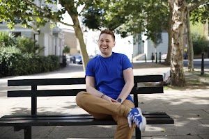 Young Man Laughing on Urban Park Bench