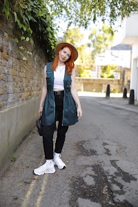 Red-Haired Woman in Green Cargo Set on European Cobblestone Street