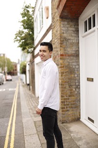 Young Man Leaning Against Brick Wall Outdoors
