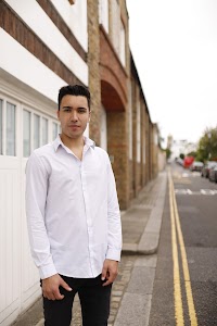 Young Man Leaning Against Brick Wall Outdoors