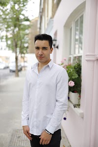 Young Man Leaning Against Brick Wall Outdoors