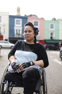 Young Woman in Wheelchair on Urban Sidewalk