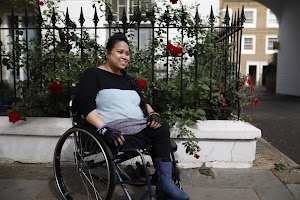 Young Woman in Wheelchair on Urban Sidewalk