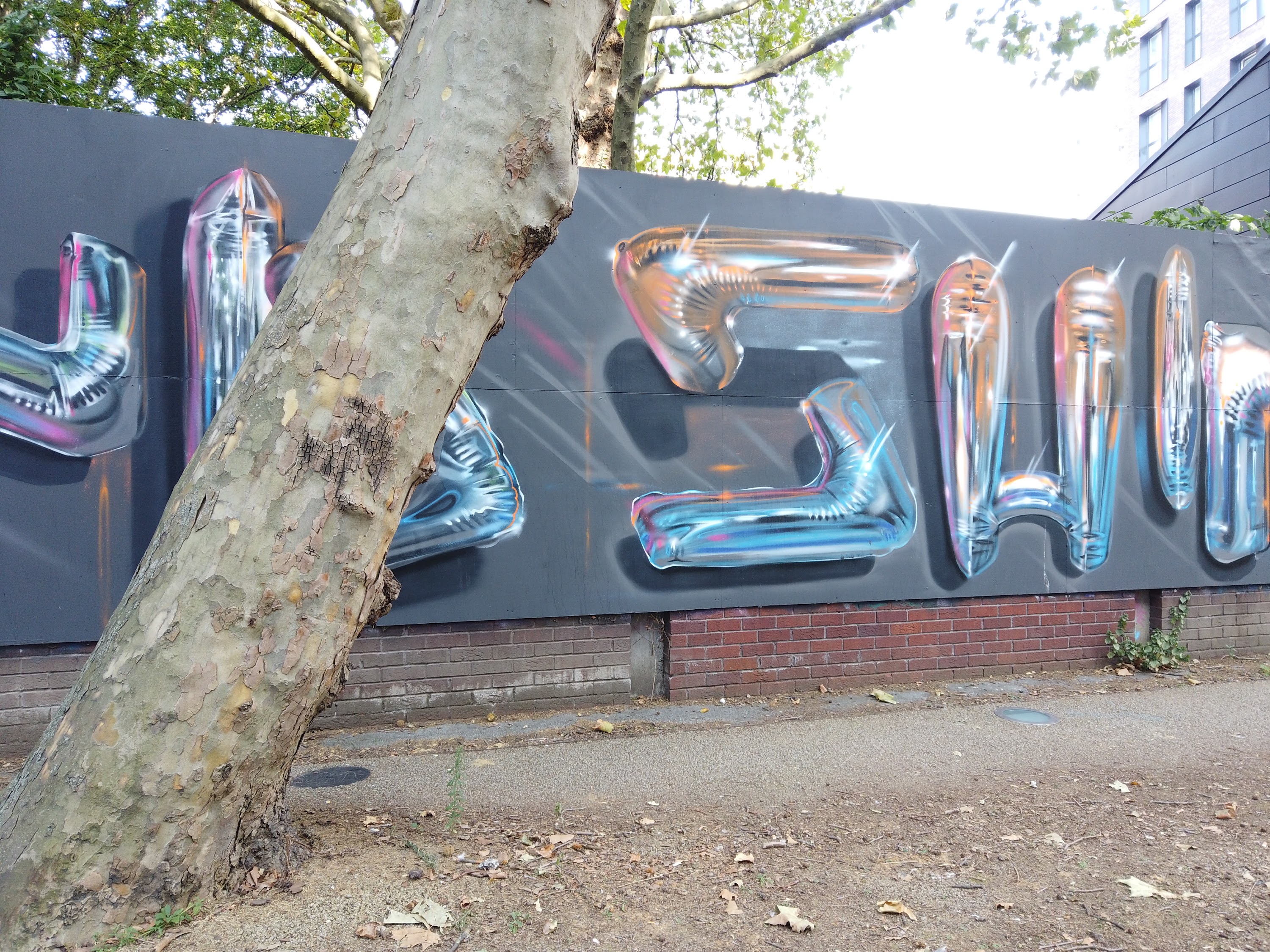Street Mural with Balloon-Style Lettering on Urban Sidewalk