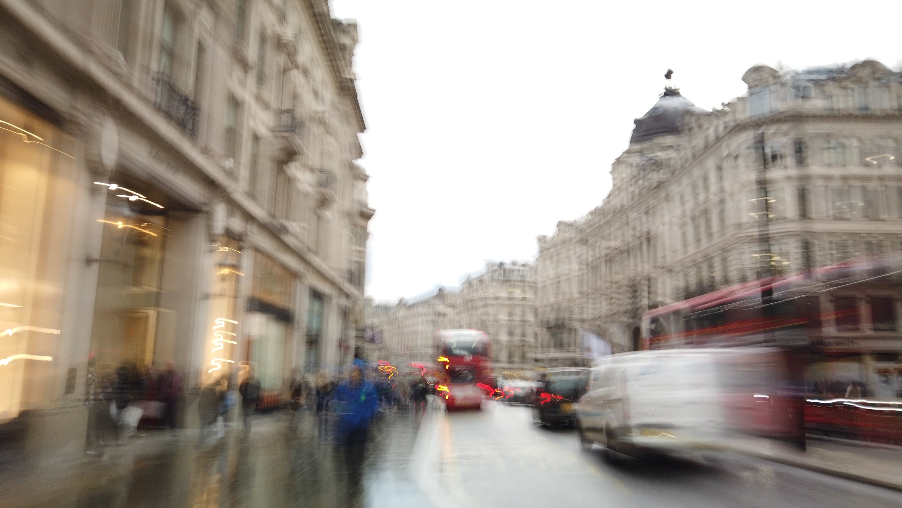 Blurred London Street Scene with Red Double-Decker Buses