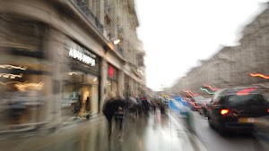 Blurred London Street Scene with Red Double-Decker Buses