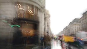 Blurred London Street Scene with Red Double-Decker Buses