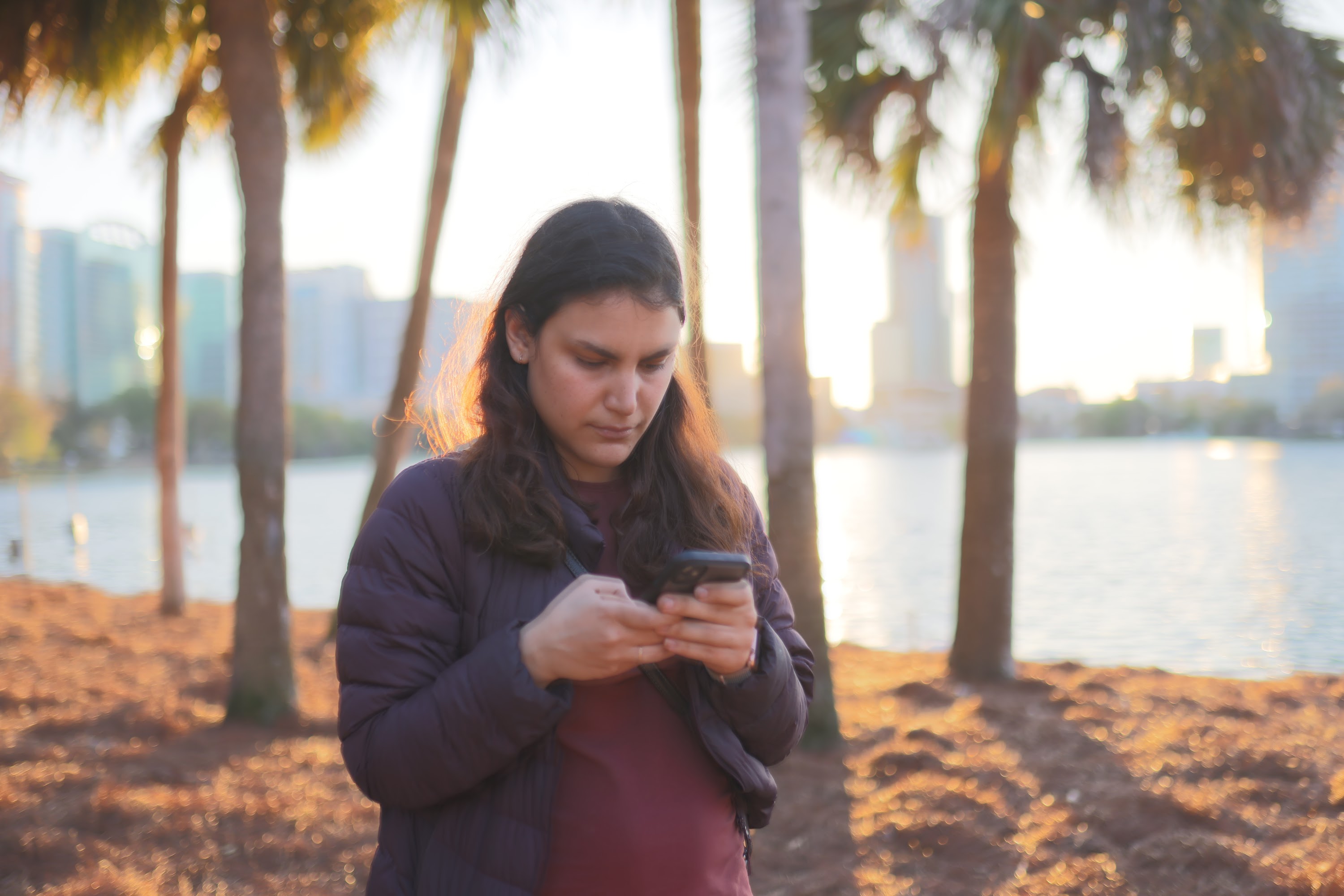 Woman Using Smartphone by the Waterfront