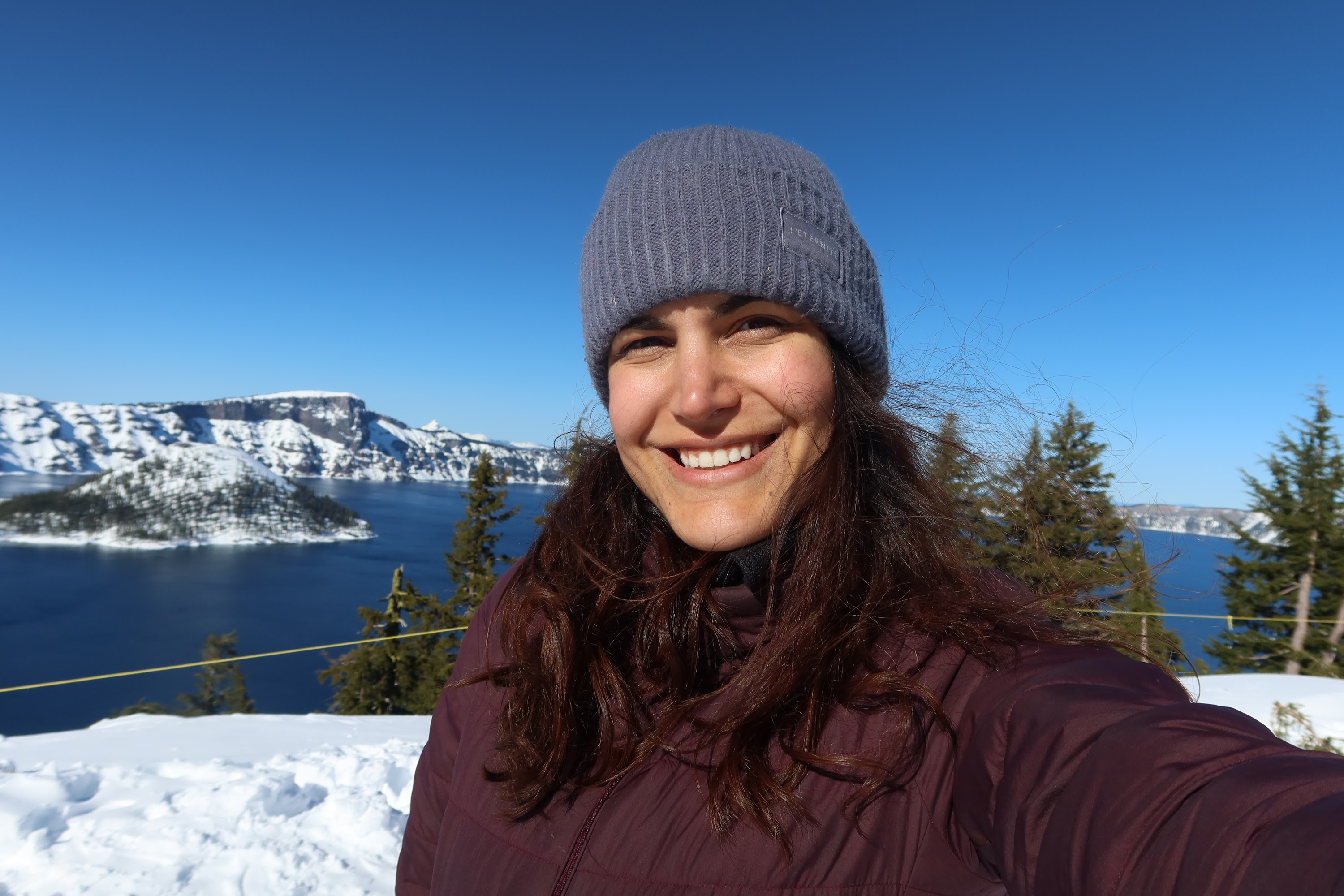 Woman Smiling in Snowy Landscape with Crater Lake