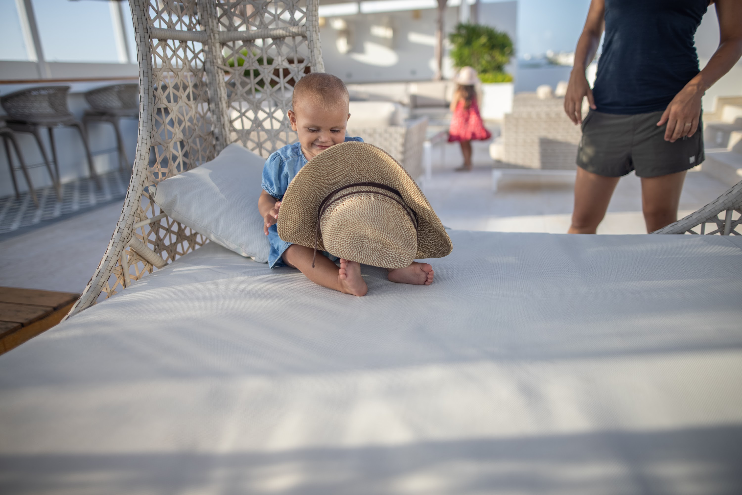 Baby Playing with Hat on Rooftop Lounge