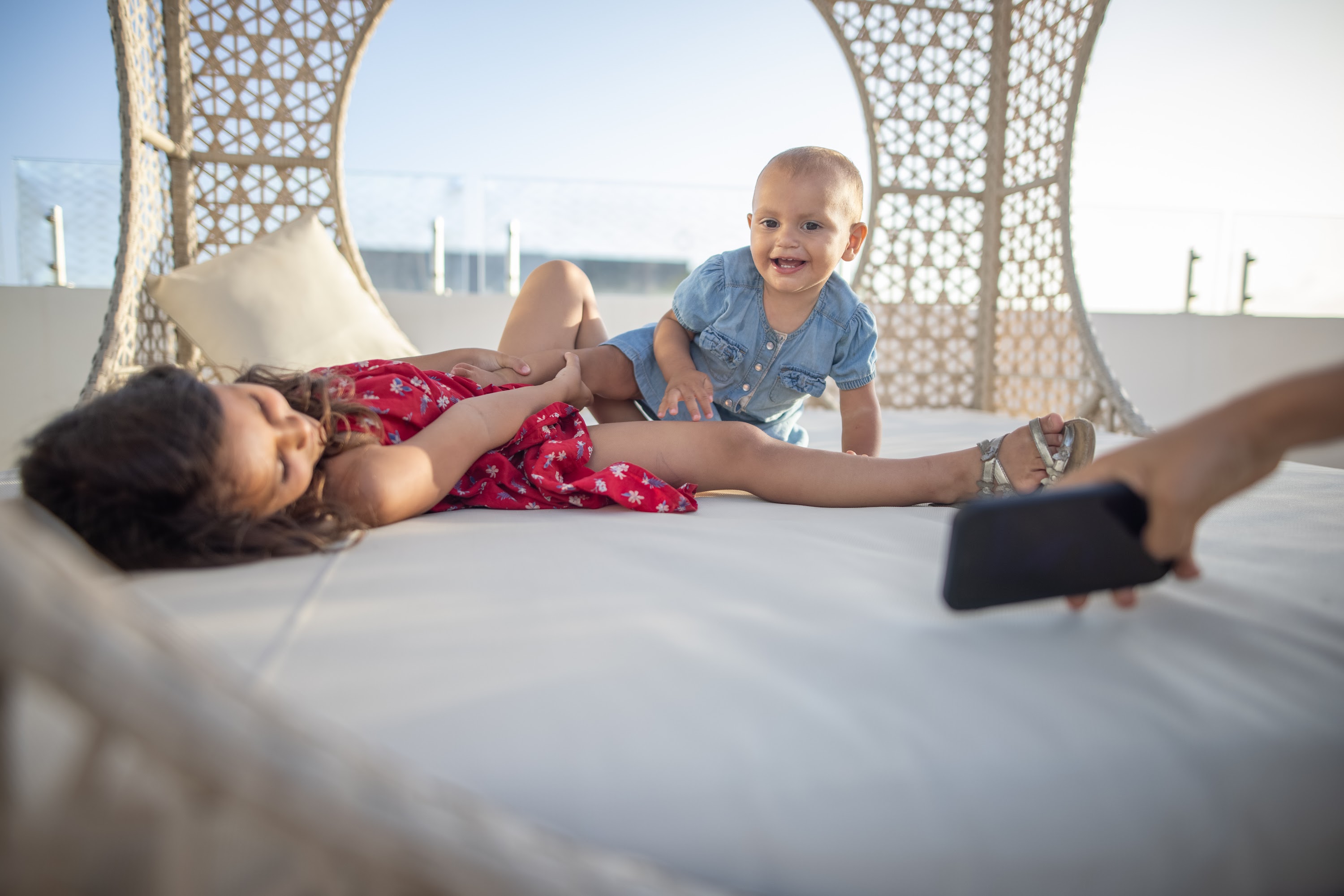 Siblings Playing on Rooftop Daybed