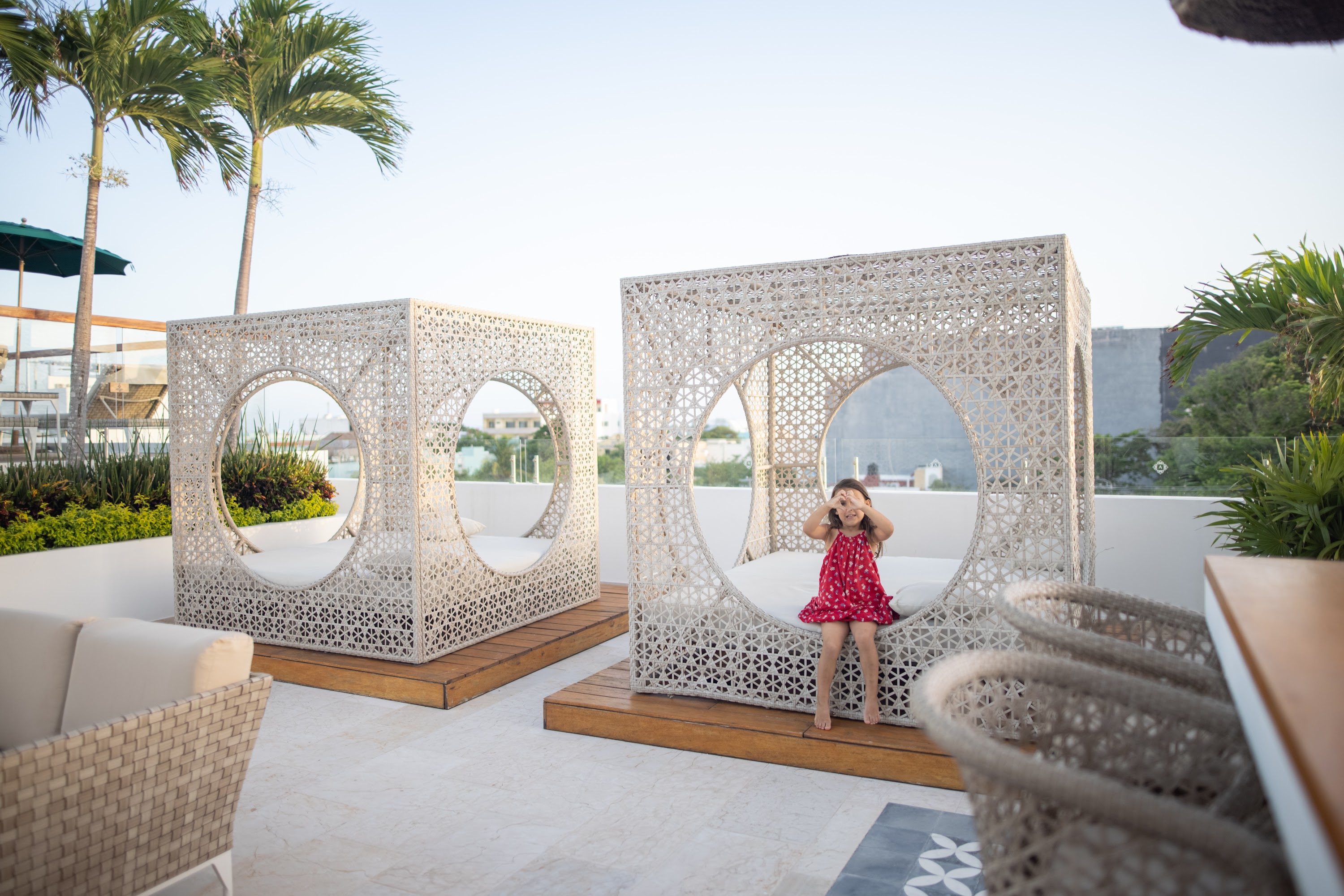 Young Girl in Red Dress Playing on a Rooftop Lounge