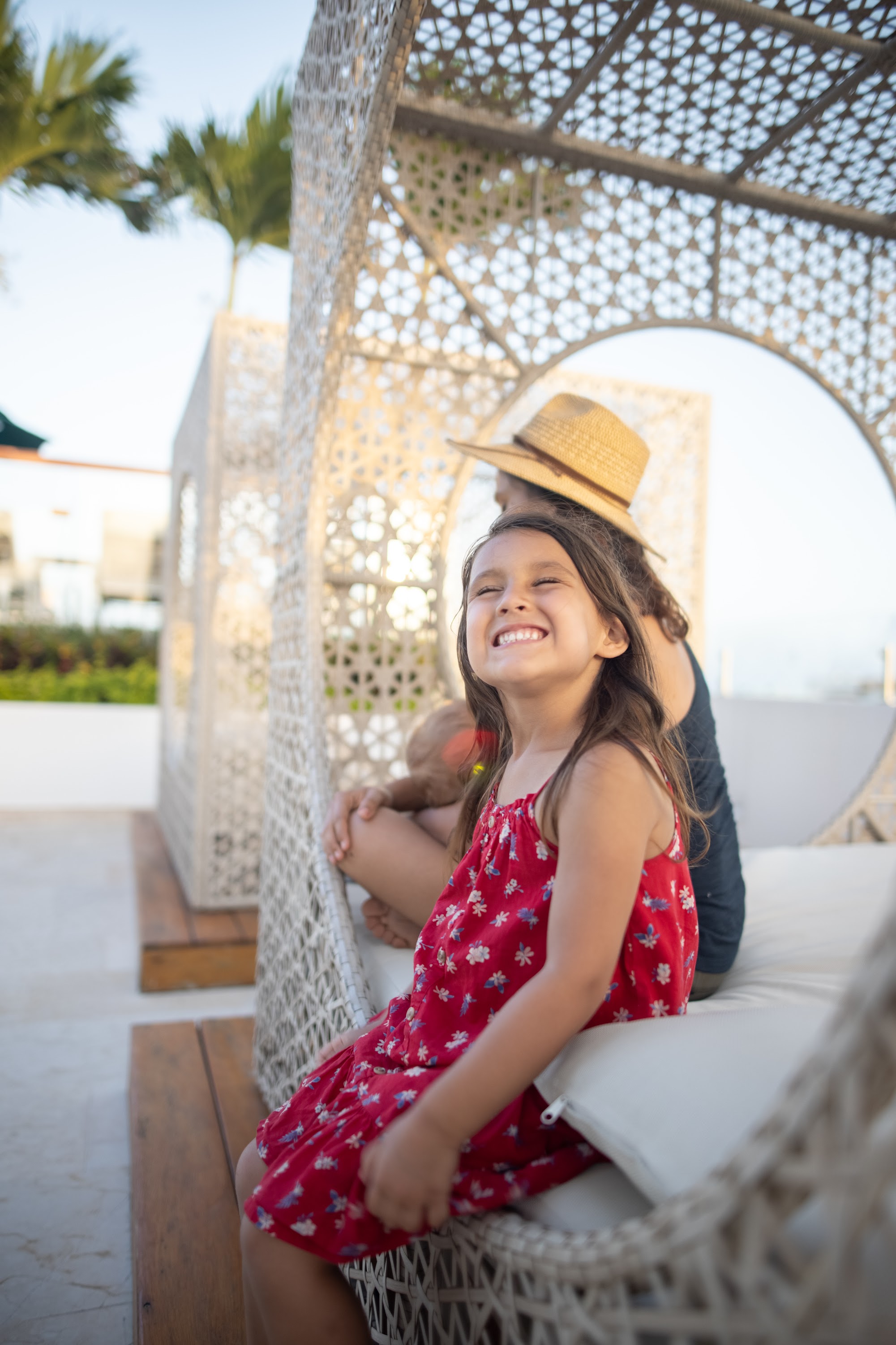 Happy Girl Laughing in a Woven Outdoor Lounger